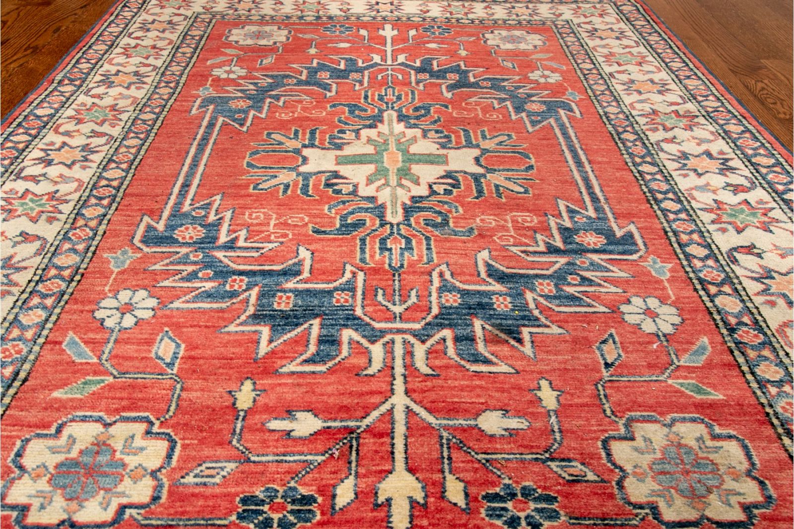 Handwoven Wool Persian area rug carpet with a lovely central medallion on a red colored ground with scroll and foliate decoration with an outer foliate decorated band on lighter colored ground